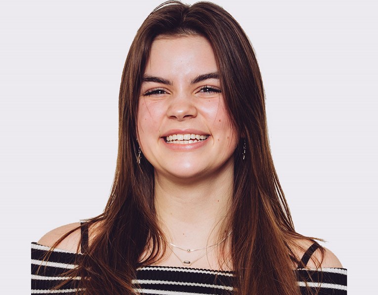 A teenage girl with long brown hair smiling